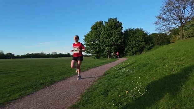 View of a woman running along a park path in Malmo Sweden.