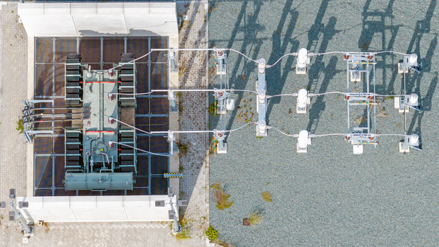 Aerial view of an electrical substation transformer with high voltage equipment and insulators on a gravel ground in Espel Flevoland Netherlands. Aerial view of an electrical substation transformer with high voltage equipment and insulators on a gravel ground in Espel Flevoland Netherlands.