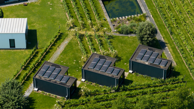 Aerial view of Ecodorp Bolderburen featuring modern houses with solar panels surrounded by lush green gardens and rows of vegetation in Almere Flevoland Netherlands. Aerial view of Ecodorp Bolderburen featuring modern houses with solar panels surrounded by lush green gardens and rows of vegetation in Almere Flevoland Netherlands.
