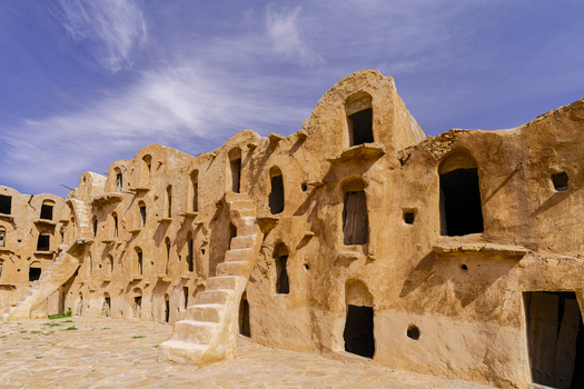View of the historic Ksar Ouled Soltane with traditional multi level vaulted granary chambers stone staircases and weathered clay walls in Tataouine Tataouine Governorate Tunisia.