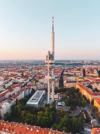 Aerial view of the Zizkov Television Tower rising above the historic rooftops and urban landscape of Prague Prague Czechia.