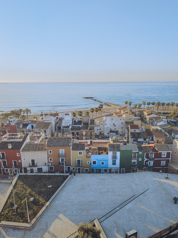 Aerial view of the iconic colorful houses along the Mediterranean coast with a sandy beach and palm trees in La Vila Joiosa Valencian Community Spain. Aerial view of the iconic colorful houses along the Mediterranean coast with a sandy beach and palm trees in La Vila Joiosa Valencian Community Spain.