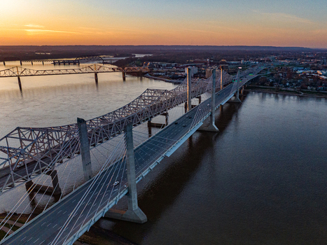 Aerial view of the Abraham Lincoln Bridge and John F. Kennedy Memorial Bridge spanning the Ohio River at sunset with the city skyline in the background Louisville Kentucky United States. Aerial view of the Abraham Lincoln Bridge and John F. Kennedy Memorial Bridge spanning the Ohio River at sunset with the city skyline in the background Louisville Kentucky United States.