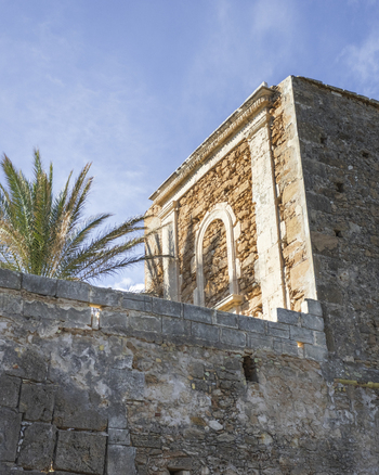 View of the historic Tonnara di Avola featuring ancient stone walls and arched architectural details under a blue sky with palm trees Avola Sicily Italy. View of the historic Tonnara di Avola featuring ancient stone walls and arched architectural details under a blue sky with palm trees Avola Sicily Italy.