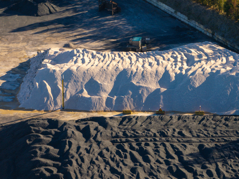 Aerial view of large piles of white salt and dark industrial gravel at a port facility in Ancona Marche Italy. Aerial view of large piles of white salt and dark industrial gravel at a port facility in Ancona Marche Italy.