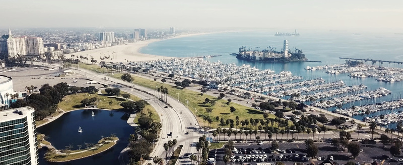 Aerial view of Marina del Rey harbor with numerous boats docked in the marina a small island sandy beach and coastal urban landscape in Los Angeles California United States.