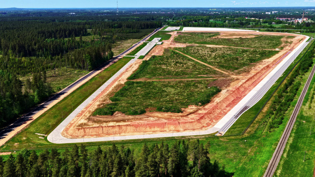 Aerial view of a large cleared land plot for industrial development bordered by dense pine forests a railway line and a paved road in Latvija. Aerial view of a large cleared land plot for industrial development bordered by dense pine forests a railway line and a paved road in Latvija.