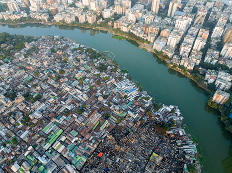 Aerial view of stark contrasts between dense settlements and modern high rises along the winding river a visual narrative of urban disparity Dhaka Dhaka Division Bangladesh. Aerial view of stark contrasts between dense settlements and modern high rises along the winding river a visual narrative of urban disparity Dhaka Dhaka Division Bangladesh.