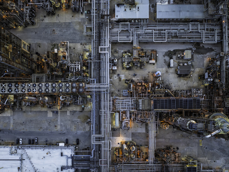 Aerial view of an oil refinery featuring complex networks of industrial pipes cooling fans and metal structures on a concrete facility floor in Illinois United States.