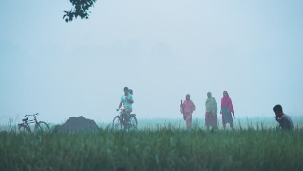 View of people in a misty field in Bogura Bangladesh.