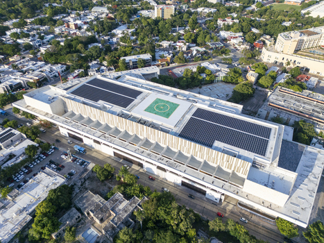 Aerial view of Centro Internacional de Congresos de Yucatan with solar panels on the roof and a helipad surrounded by urban landscape in Merida Yucatan Mexico. Aerial view of Centro Internacional de Congresos de Yucatan with solar panels on the roof and a helipad surrounded by urban landscape in Merida Yucatan Mexico.