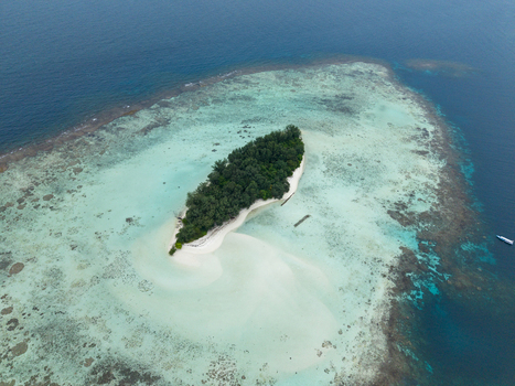 Aerial view of the island s vibrant blues and greens contrast with the sandy shores and lush vegetation Cemara Kecil Island Karimunjawa Central Java Indonesia.