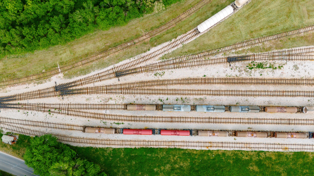 Aerial view of freight trains with tanker cars parked on multiple railway tracks surrounded by lush green trees and grassy fields Sabac Vojvodina Serbia. Aerial view of freight trains with tanker cars parked on multiple railway tracks surrounded by lush green trees and grassy fields Sabac Vojvodina Serbia.