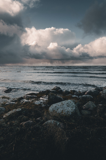 View of Vormsi rocky shoreline with dark moody clouds over the sea in Laane County Estonia.