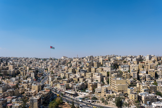 View of the Raghadan Flagpole rising above the dense urban landscape of beige stone buildings in Amman Amman Governorate Jordan.