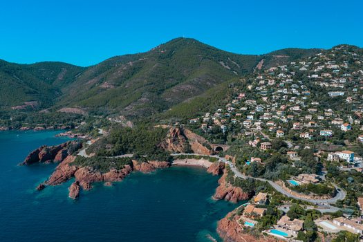 Aerial view of Le Trayas coastal landscape with red rock cliffs turquoise waters winding roads and hillside villas Saint Raphael Provence Alpes Cote d Azur France. Aerial view of Le Trayas coastal landscape with red rock cliffs turquoise waters winding roads and hillside villas Saint Raphael Provence Alpes Cote d Azur France.