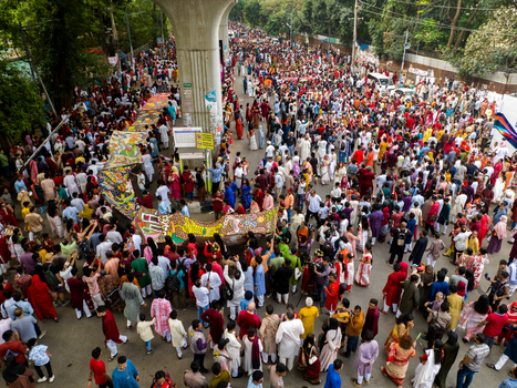 Dhaka Bangladesh 13 April 2026 Aerial view of a vibrant dense crowd in colorful attire a river of humanity flowing past a massive concrete pillar.