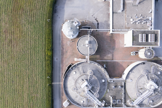 Aerial view of a wastewater treatment plant with circular sedimentation tanks industrial infrastructure and adjacent green fields in Richmond British Columbia Canada. Aerial view of a wastewater treatment plant with circular sedimentation tanks industrial infrastructure and adjacent green fields in Richmond British Columbia Canada.