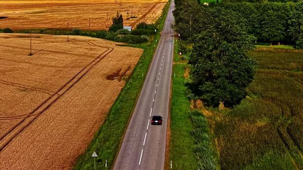 Aerial view of a car driving on a road Latvia. Aerial view of a car driving on a road Latvia.