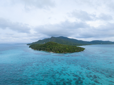 Aerial view of lush green island meeting the turquoise sea under a cloudy sky near Tanjung Gelam Beach Karimunjawa Central Java Indonesia. Aerial view of lush green island meeting the turquoise sea under a cloudy sky near Tanjung Gelam Beach Karimunjawa Central Java Indonesia.