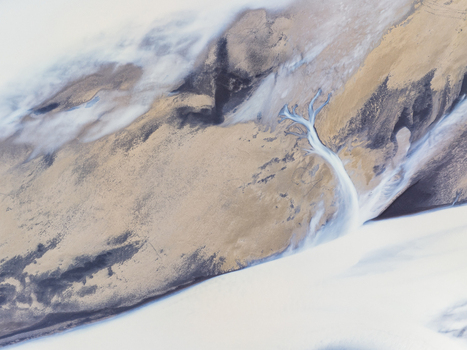 Aerial view of a glacial river delta with intricate braided channels of sediment rich water flowing across a vast barren volcanic landscape in Iceland. Aerial view of a glacial river delta with intricate braided channels of sediment rich water flowing across a vast barren volcanic landscape in Iceland.
