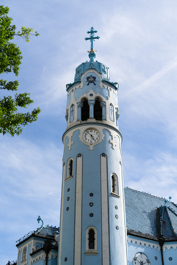 View of the Art Nouveau Blue Church tower with its distinctive clock and blue facade under a clear sky in Bratislava Bratislava Region Slovakia. View of the Art Nouveau Blue Church tower with its distinctive clock and blue facade under a clear sky in Bratislava Bratislava Region Slovakia.