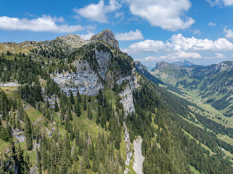 Aerial view of the rugged cliffs and pine forests of the Niederhorn mountain range in the Justistal valley near Sigriswil Bern Switzerland. Aerial view of the rugged cliffs and pine forests of the Niederhorn mountain range in the Justistal valley near Sigriswil Bern Switzerland.