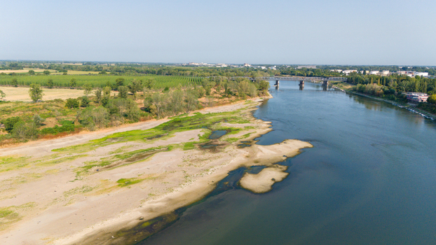 Aerial view of the Po River with low water levels and exposed riverbed sediments caused by a summer heatwave and drought near Castelvetro Piacentino Emilia Romagna Italy. Aerial view of the Po River with low water levels and exposed riverbed sediments caused by a summer heatwave and drought near Castelvetro Piacentino Emilia Romagna Italy.