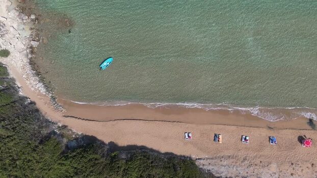 Aerial view of a beach with a small blue boat in Northern Cyprus.