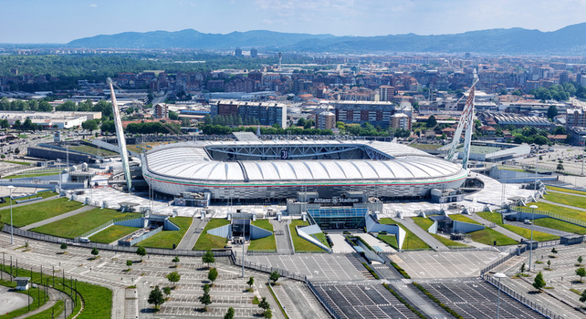 Torino Italy 09 May 2026 Aerial view of Allianz Stadium with its iconic white roof and support masts surrounded by parking areas and the urban landscape of Turin under a clear sky.