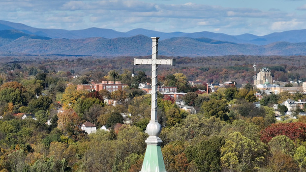 Aerial view of a church spire with a cross overlooking the town of Lynchburg surrounded by autumn foliage and mountains in Lynchburg Virginia United States. Aerial view of a church spire with a cross overlooking the town of Lynchburg surrounded by autumn foliage and mountains in Lynchburg Virginia United States.
