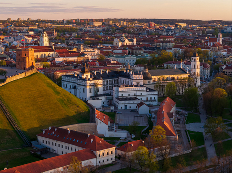 Aerial view of Gediminas Tower on a green hill and the Palace of the Grand Dukes under golden hour light in Vilnius County Lithuania. Aerial view of Gediminas Tower on a green hill and the Palace of the Grand Dukes under golden hour light in Vilnius County Lithuania.