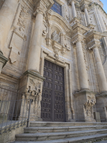 View of the ornate stone facade and grand wooden entrance doors of the Igrexa da Santa Eufemia in Ourense Ourense Spain.