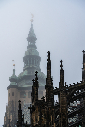 View of the gothic spires of St. Vitus Cathedral shrouded in thick morning fog in Prague Prague Czechia.