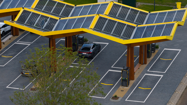 Oostzaan Netherlands 09 June 2026 Aerial view of Fastned Charging Station with solar panel roof electric vehicles parked at charging bays and surrounding pavement.