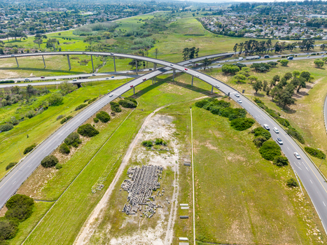Aerial view of the highway interchange in Brackenfell with cars driving on the roads surrounded by green grassy fields and suburban landscape in Cape Town Western Cape South Africa. Aerial view of the highway interchange in Brackenfell with cars driving on the roads surrounded by green grassy fields and suburban landscape in Cape Town Western Cape South Africa.
