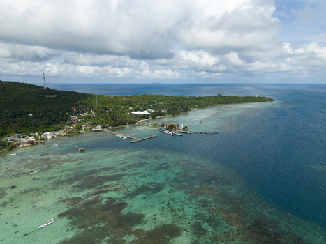 Aerial view of the Karimunjawa ferry harbour where turquoise waters meet the lush coastline under a vast sky Karimunjawa Jawa Tengah Indonesia. Aerial view of the Karimunjawa ferry harbour where turquoise waters meet the lush coastline under a vast sky Karimunjawa Jawa Tengah Indonesia.
