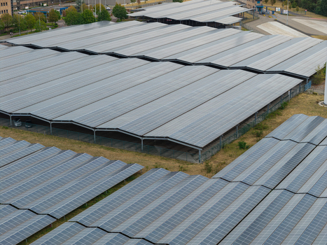 Aerial view of the Haven Genk solar power plant featuring extensive rows of photovoltaic panels installed on industrial structures in Genk Vlaanderen Belgium.