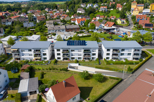 Aerial view of modern apartment buildings with solar panels on the roof and green gardens in Erlangen Bavaria Germany.