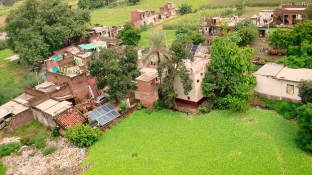 Aerial view of solar panels on village rooftops India.