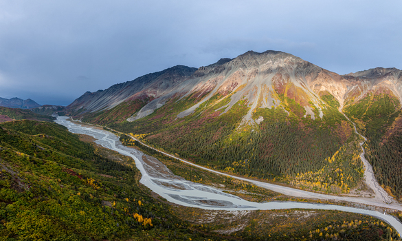 Aerial view of Rainbow Ridge with dramatic mountain slopes vibrant autumn foliage and a winding braided river in Southeast Fairbanks Census Area Alaska United States. Aerial view of Rainbow Ridge with dramatic mountain slopes vibrant autumn foliage and a winding braided river in Southeast Fairbanks Census Area Alaska United States.