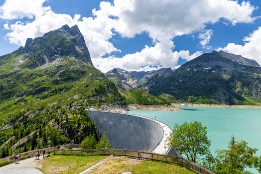 View of VerticAlp Emosson and the Emosson Dam with its turquoise reservoir surrounded by dramatic alpine peaks and a clear blue sky in Le Chatelard Fribourg Switzerland. View of VerticAlp Emosson and the Emosson Dam with its turquoise reservoir surrounded by dramatic alpine peaks and a clear blue sky in Le Chatelard Fribourg Switzerland.