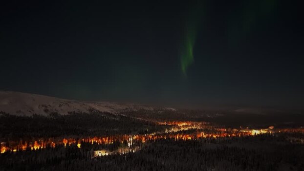 Aerial view of northern lights over the snowy landscape Finland.