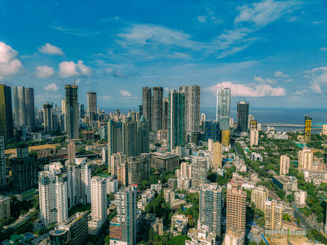 Aerial view of the dense skyline of skyscrapers and modern residential buildings under a blue sky with scattered clouds in Mumbai Maharashtra India. Aerial view of the dense skyline of skyscrapers and modern residential buildings under a blue sky with scattered clouds in Mumbai Maharashtra India.