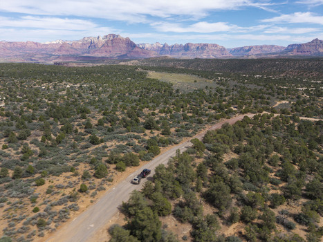 Aerial view of an SUV pulling a teardrop camper trailer on Gooseberry Mesa with Zion National Park in the background Hurricane Utah United States. Aerial view of an SUV pulling a teardrop camper trailer on Gooseberry Mesa with Zion National Park in the background Hurricane Utah United States.