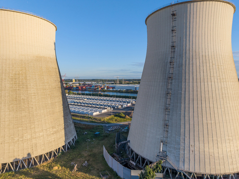 Aerial view of the Cargovil battery energy storage system situated between two large industrial cooling towers in an energy infrastructure hub in Vilvoorde Vlaanderen Belgium. Aerial view of the Cargovil battery energy storage system situated between two large industrial cooling towers in an energy infrastructure hub in Vilvoorde Vlaanderen Belgium.