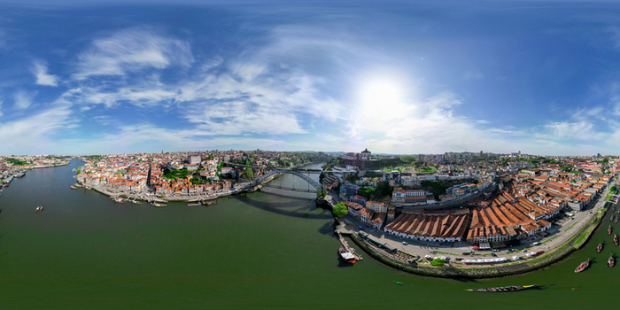 Aerial view of the iconic Luis I Bridge spanning the Douro River between the historic Ribeira district and Vila Nova de Gaia under a blue sky in Porto Porto District Portugal.