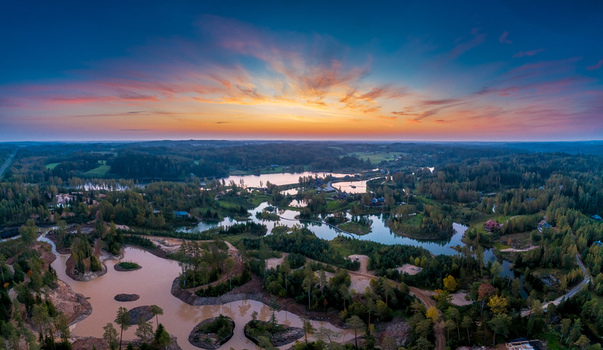 Aerial view of a serene landscape with winding lakes dense forests and a vibrant sunset sky in Latvia. Aerial view of a serene landscape with winding lakes dense forests and a vibrant sunset sky in Latvia.
