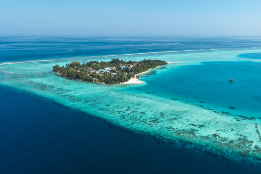 Aerial view of Vaanee island surrounded by turquoise lagoon waters coral reefs and lush tropical vegetation in Vaanee Dhaalu Atoll Maldives. Aerial view of Vaanee island surrounded by turquoise lagoon waters coral reefs and lush tropical vegetation in Vaanee Dhaalu Atoll Maldives.