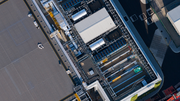 Aerial view of the industrial rooftop featuring complex HVAC systems ventilation units and piping infrastructure in Longcross England United Kingdom.